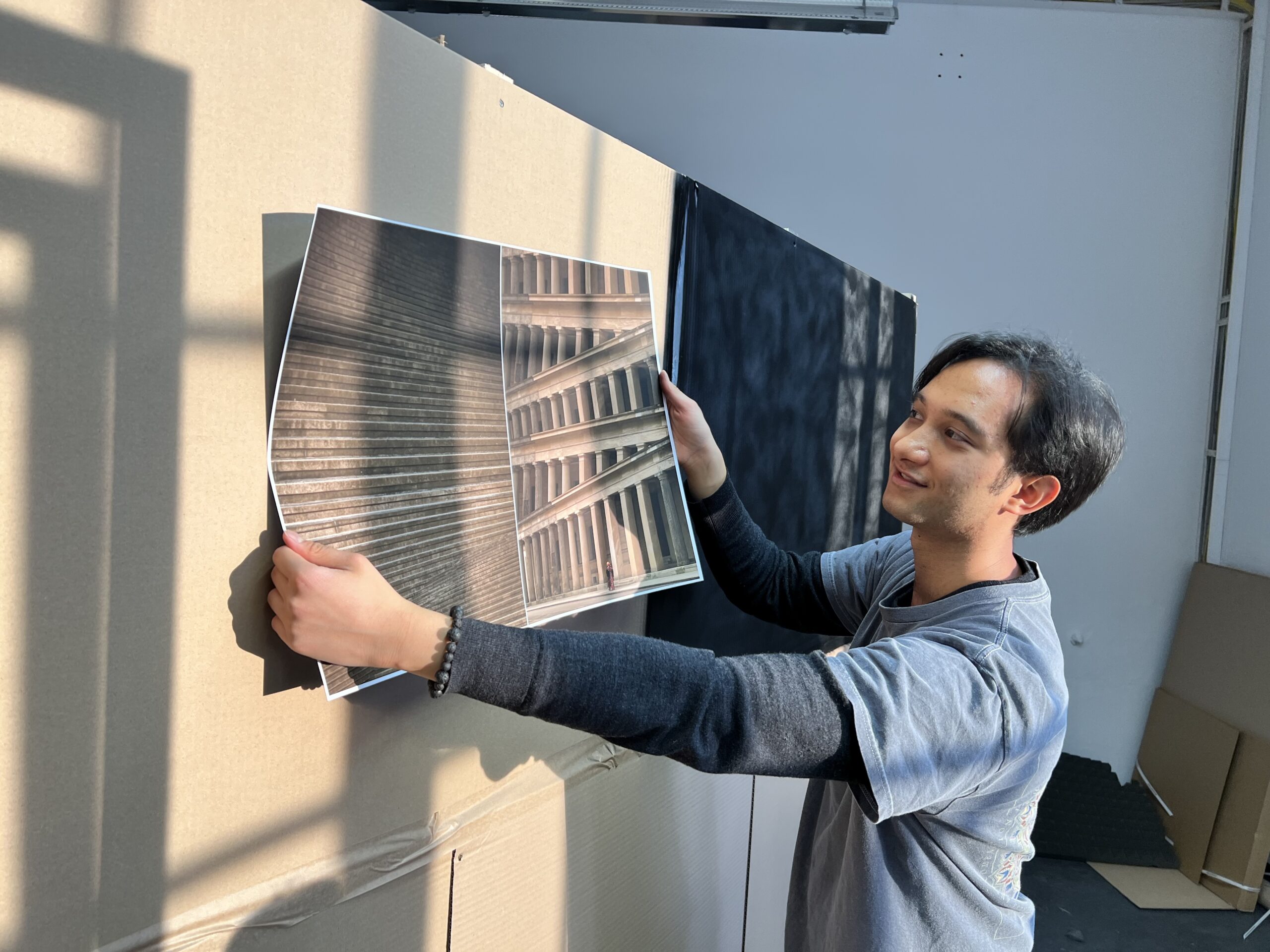 Photograph of student holding photographic prints of their work