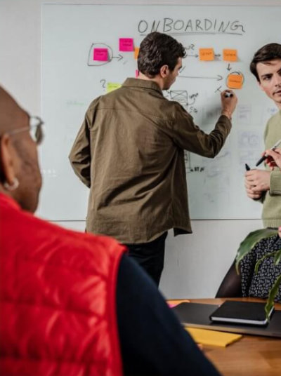 Photograph of students drawing on a whiteboard as part of a design brainstorming sorting exercise