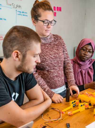 Photograph of students assembling a robot spider as part of an IoT workshop